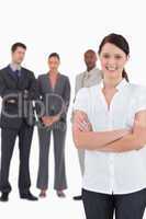 Businesswoman with arms folded and three colleagues behind her