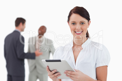 Businesswoman with tablet and colleagues behind her