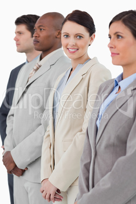 Smiling businesswoman standing between her associates
