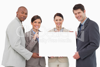 Smiling businessteam holding blank sign together