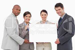 Smiling businessteam holding blank sign together