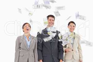 Money falling down on smiling businessteam