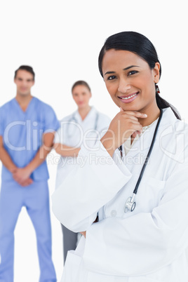 Smiling doctor with staff behind her