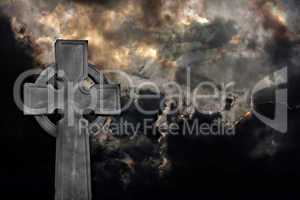 Graveyard cross against storm clouds