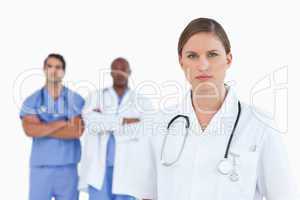 Female doctor with male colleagues behind her