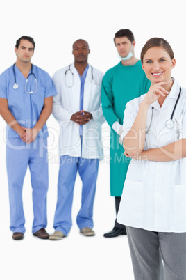 Smiling doctor with male staff members behind her