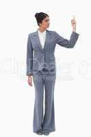 Businesswoman looking at hand while pointing up