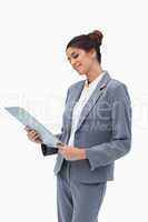 Smiling businesswoman looking at clipboard