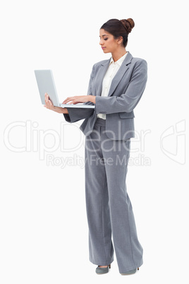 Businesswoman using laptop while standing