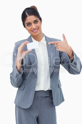 Smiling saleswoman pointing at blank business card Smiling saleswoman pointing at blank business card