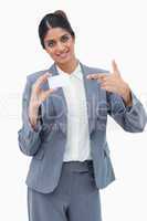 Smiling saleswoman pointing at blank business card