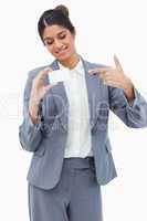 Smiling tradeswoman pointing at blank business card