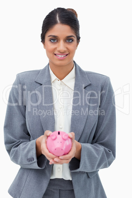 Smiling bank employee holding piggy bank