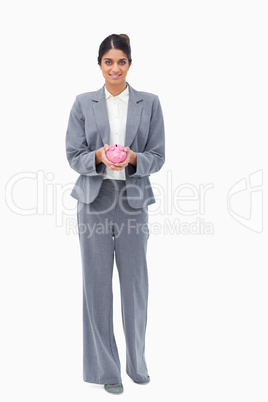 Smiling bank employee with piggy bank in her hands