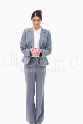 Smiling bank assistant with piggy bank