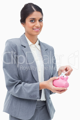 Smiling bank assistant putting money into piggy bank