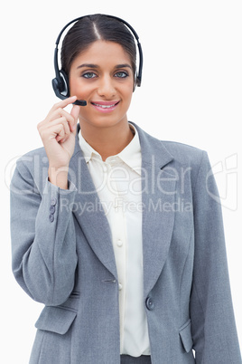 Smiling call center agent adjusting microphone