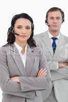Call center agents with headsets and arms folded