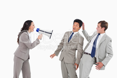 Businesswoman with megaphone yelling at colleagues