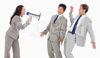 Businesswoman with megaphone shouting at colleagues