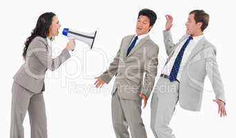 Businesswoman with megaphone shouting at colleagues