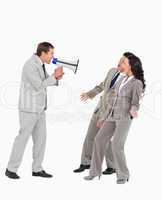 Businessman with megaphone yelling at associates