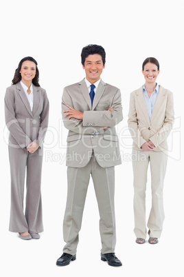 Smiling businessman with his staff behind him