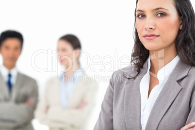 Confident businesswoman with colleagues behind her