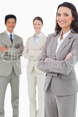 Smiling tradeswoman with folded arms and associates behind her