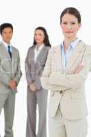 Confident tradeswoman with arms folded and team behind her