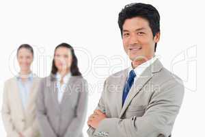 Confident smiling businessman with his team behind him