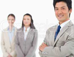 Smiling young businessman with colleagues behind him
