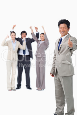 Salesman giving thumb up while getting celebrated