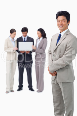 Salesman with colleagues and laptop behind him