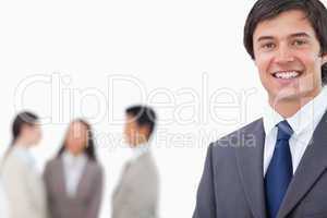 Smiling young businessman with team behind him