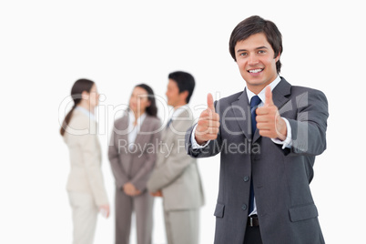 Salesman giving his approval with team behind him