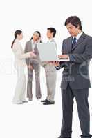 Salesman with laptop and team behind him