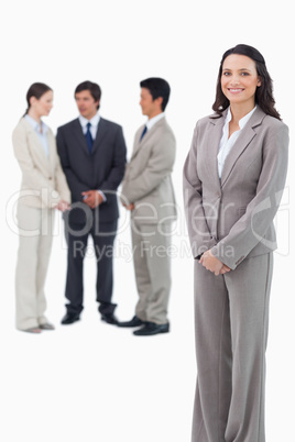 Smiling saleswoman with her team behind her