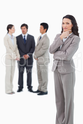 Thinking saleswoman with team behind her