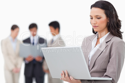 Saleswoman with notebook and colleagues behind her