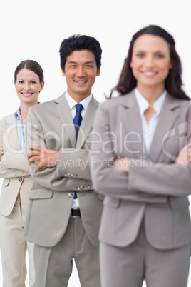 Smiling salesteam standing with folded arms