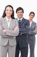 Smiling salesteam standing together with folded arms
