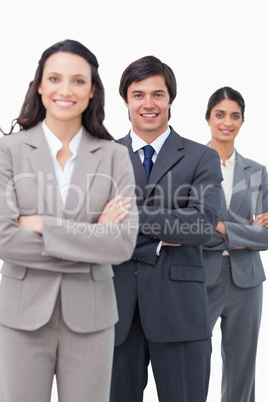 Smiling young salesteam standing together with arms folded