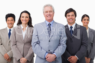 Smiling mature businessman standing with team