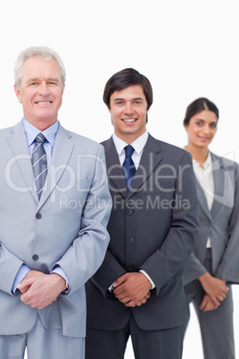 Smiling mature businessman with young employees