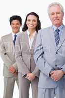 Mature businessman standing with employees