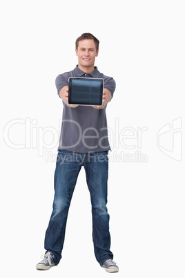 Smiling young man showing screen of tablet computer