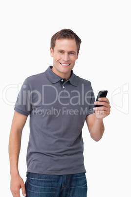 Smiling young man holding his cellphone