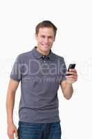 Smiling young man holding his cellphone