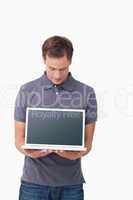 Young man showing screen of his notebook